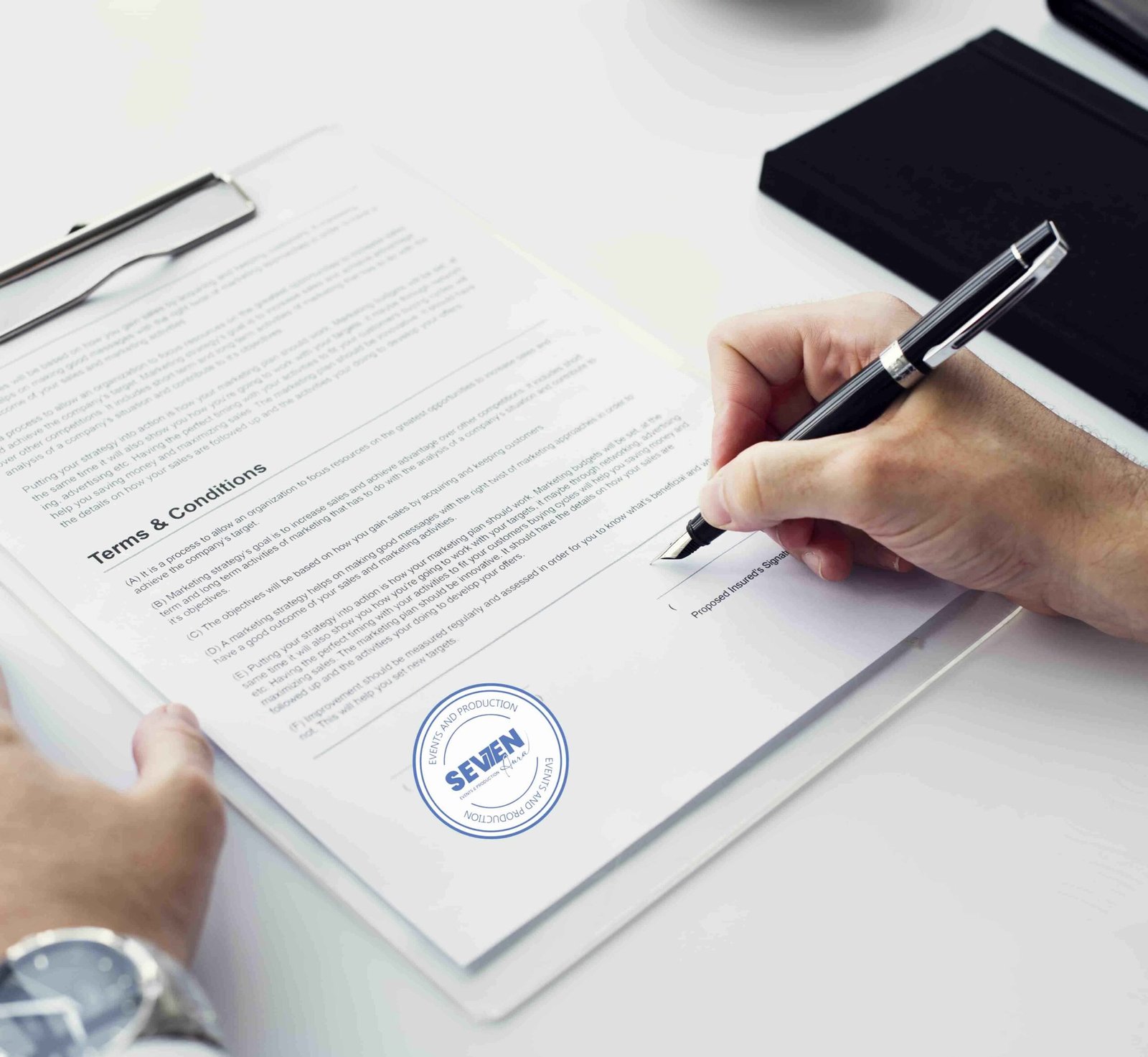 Client signing event proposal and contract document in Seven Aura’s office